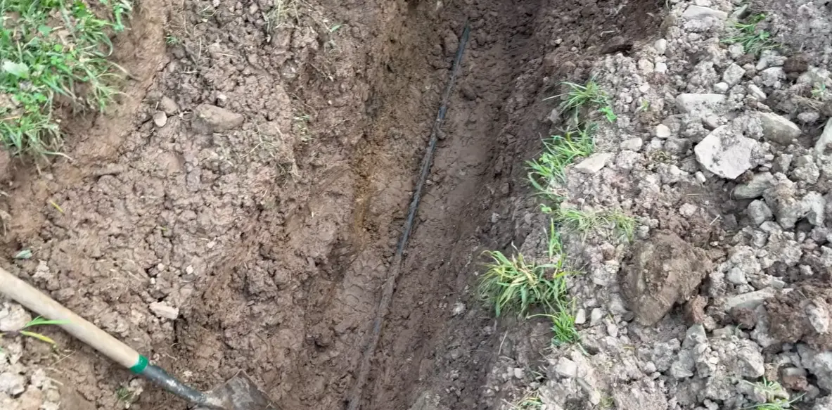 Underground leak detection technician using ground microphone equipment to locate a buried pipe leak in a Portland yard